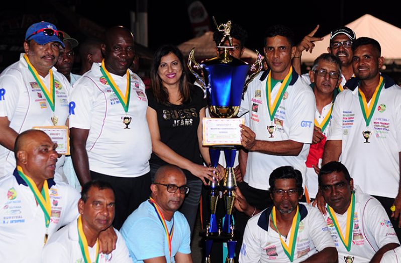 Mrs. Devi Sunich hands over the winning Trophy Stall trophy and cash prize of $600,00 to GFSCA captain Ramo Malone as other members celebrate their win. (Delano Williams photo)