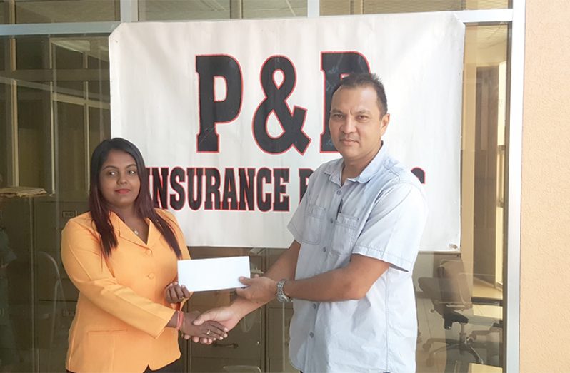 Andy Phang (right) collects sponsorship from P&P Insurance Brokers and Consultants Limited.