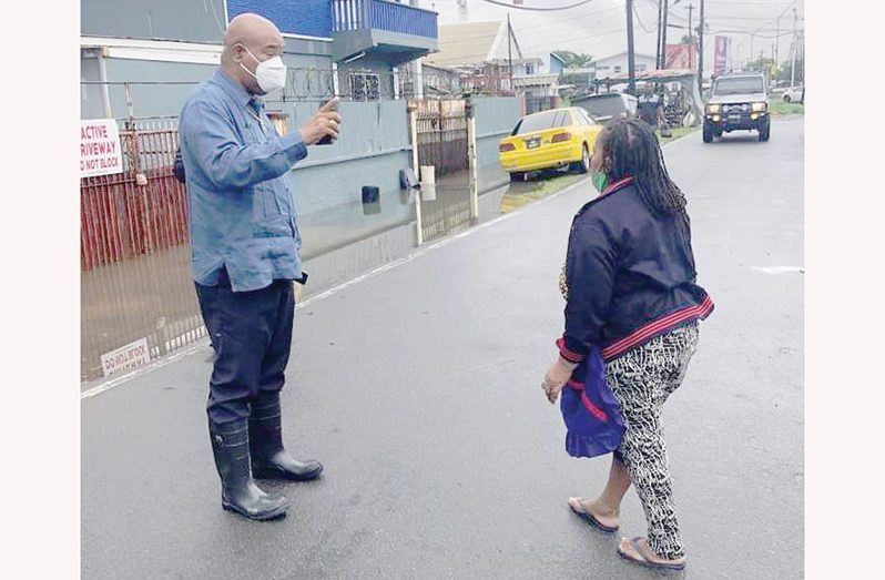 Public Works Minister, Juan Edghill, interacting with a Georgetown resident during an assessment of the flood on Sunday morning