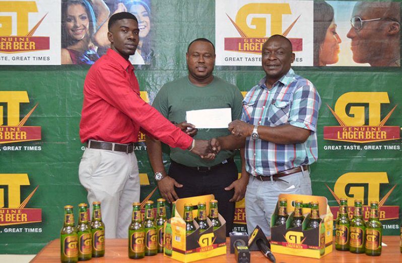 Mark Allen is seen collecting the sponsorship cheque from Banks Communications Officer in the presence of Troy Mendonca.