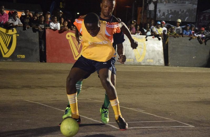Flashback: Tyrese Forde of Leopold Street shields the ball from a California Square player, during their quarterfinals showdown in the Guinness Greatest of the Streets Georgetown Zone at the National Cultural Centre tarmac.