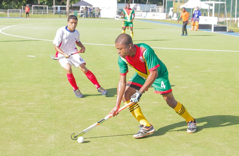 Guyana’s Kareem McKenzie making a move against Puerto Rico’s Gilberto Monserrate during his side’s 4 – 1 win at the CAC hockey qualifiers in Jamaica.
