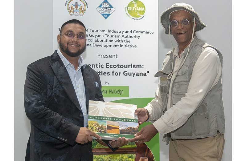 (from left) Director of GTA Kamrul Baksh receiving a book from Professor Hitesh Mehta on Monday (Japheth Savory photos)