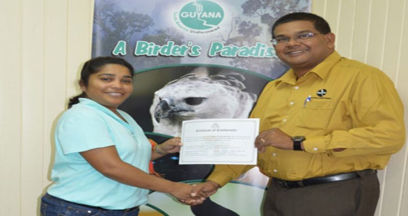 Old Fort’s Ms. Camille Boodhoo receiving the certification from GTA’s Mr Indranauth Haralsingh
