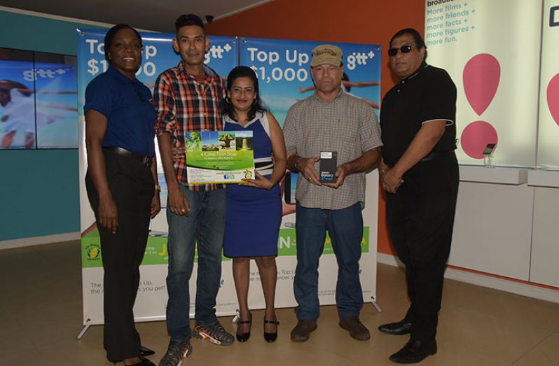 GTT Director of Retail Sales Allison Dundas (left) and Fly Jamaica’s Commercial Manager Carl Bowen (right), with promotion winners George Mahase and his wife and consolation winner, Paul Fernandes