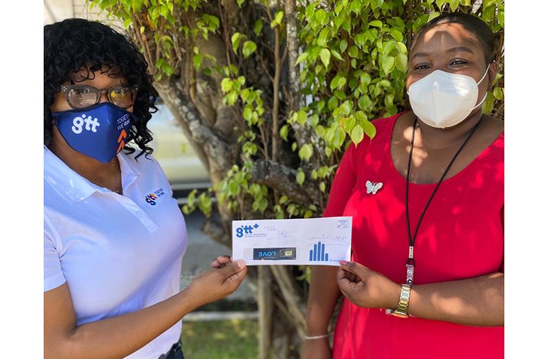 GTT's PR Manager, Jasmin Harris hands over SIMs to GPHC's Strategic Planning and Communications Manager, Chelauna Providence
