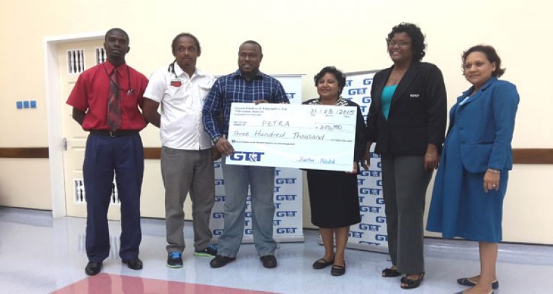 Here you go, sir! GT&T’s Senior Marketing Officer Angenie Hackett (3rd from right) hands over the cheque for $300 000 to Director of Petra Organisation, Troy Mendonca, in the presence of her PRO, Alison Parker, and other members of both entities.