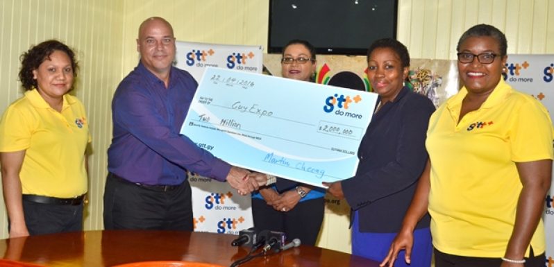 GTT+ Marketing Director, Daniel Jilesen presents the cheque of $2M to one of the GuyExpo officials in the presence of other representatives of the company.