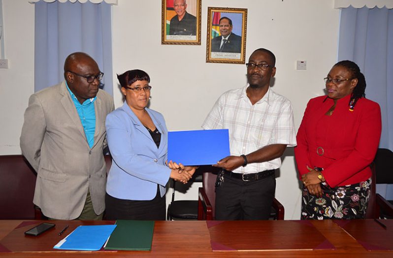 Permanent Secretary of the Ministry of Education Adele Clarke and Guyana Teachers’ Union (GTU) President Mark Lyte (centre), officially sign the agreement on salaries and non-salary benefits for teachers. The process was witnessed by Chief Education Officer (CEO) Marcel Hutson and GTU General-Secretary Coretta McDonald (Adrian Narine photo)