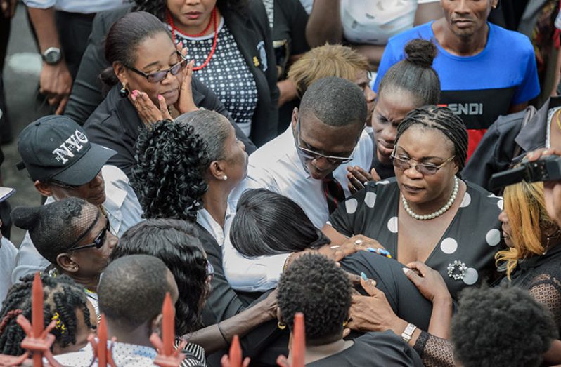 GTU’s Coretta McDonald and other activists comforting the distraught teacher as she exited the court on Monday morning (Photos by Delano Williams)