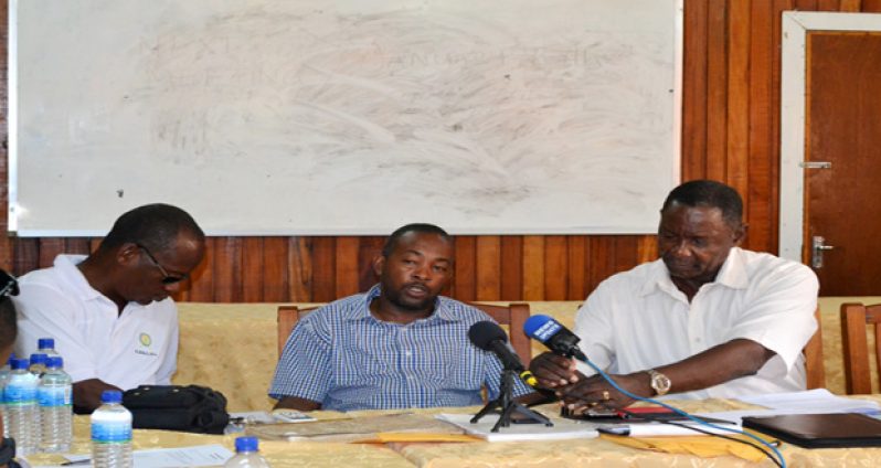 GTUC head, Lincoln Lewis, fixing the microphones on Friday as former employee of RUSAL, Lennox Smith, addresses the media about his dismissal from the company