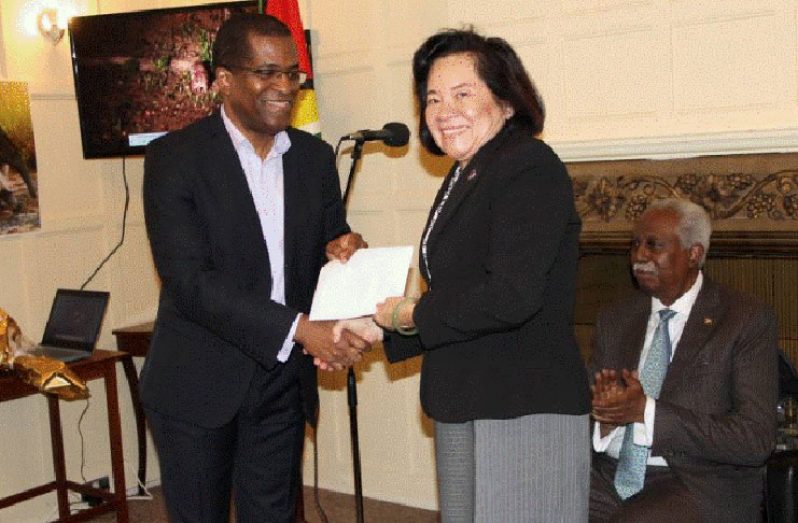 GUSDA chair, Orin Alexander presents the donation to First Lady, Mrs. Sandra Granger as Guyana’s High Commissioner to the UK,Hamley Case, looks on.