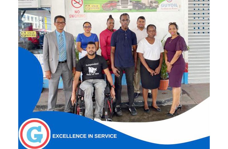 GUYOIL Chairman, Paul Cheong (far left); General Manager (ag) of GUYOIL Molly Hassan (far right), newly employed staff Ashshell Benn, Peter Fraser, and the recipient of a gift, Uttamkumar Isurdeen and senior staff of Guyoil (Back)