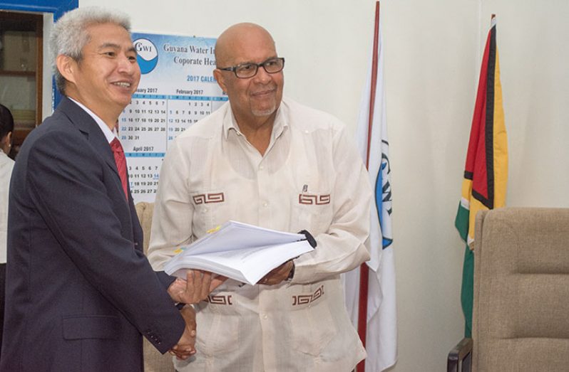 Sinohydro Project Manager, Hong Zhou, congratulates GWI Managing Director, Dr Richard Van-West Charles, following the signing of the multimillion-dollar project (Samuel Maughn photo)