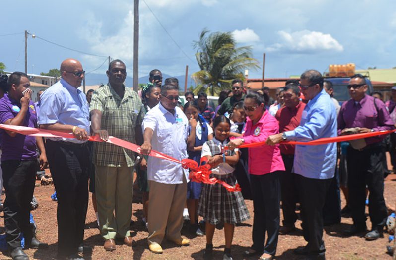 A resident of Lethem with the support of GWI, regional and government officials cut the ribbon to declare the GWI commercial office open