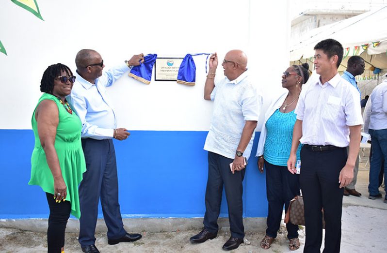 Director General of the Ministry of the Presidency, Joseph Harmon, and GWI's Managing Director, Dr. Richard Van-West Charles unveil the plaque at the facility, as REO of Region Three, Jennifer Ferreira-Dougall, and other officials look on (GWI photo)