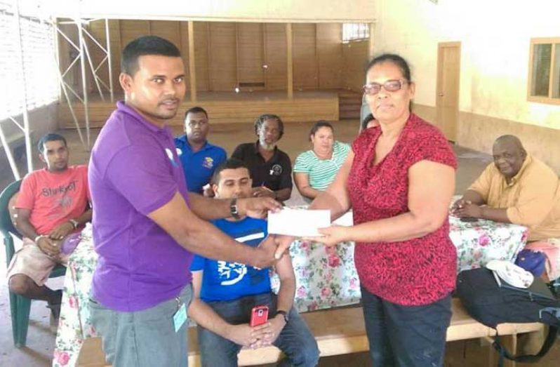 GWI Executive Director, Project Implementation and Partnership Building- Mr. Ramchand Jailal hands over cheque to Chairperson of the Matakai NDC, Ms. Magrette Lawrence in the presence of GWI & Regional officials