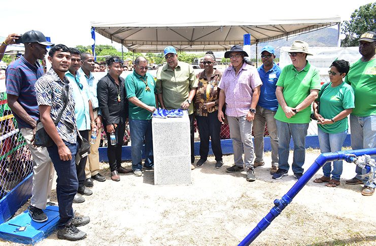 Minister of Indigenous Peoples' Affairs, Sydney Allicock and GWI's Managing Director, Dr. Richard Van-West Charles, unveil the plaque to commission the Karasabai water-supply system. Also in the photo are other GWI officials and residents