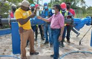 GWI's Technical team and CEO, Shaik Baksh observe a sample of water from the new well