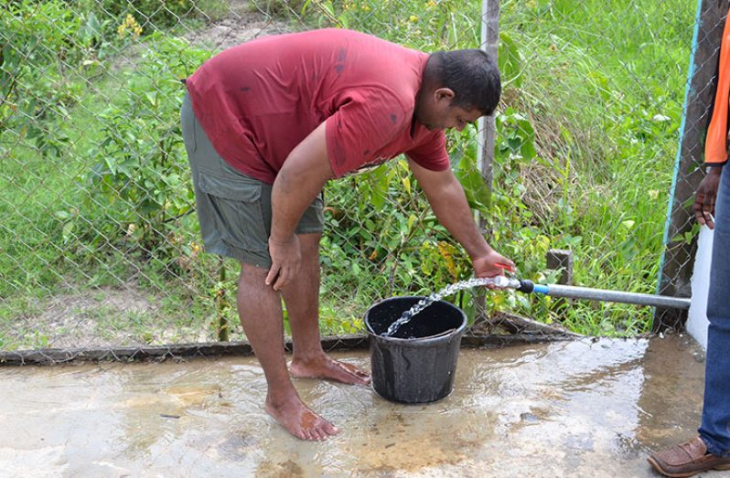 A resident of Hand-en-Veldt receiving water through his tap
