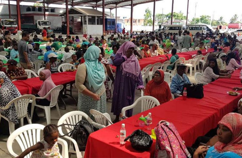 Elderly citizens and children waiting to be served meals.