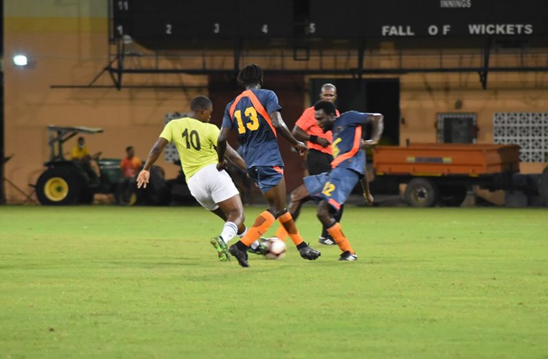 Georgetown's Ryan Hackett (10) tries to win possession against West Demerara's Andre Hector (12) on the first night of the Bounce Back Football Tournament.