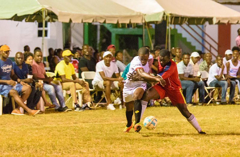 In this Samuel Maughn photo, a Police FC  attacker (white) gets by the Riddim Squad defender.