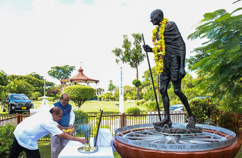 Prime Minister Moses Nagamootoo pays  floral tribute to Gandhi with the help of  Indian High Commissioner, Mr Mahalingam