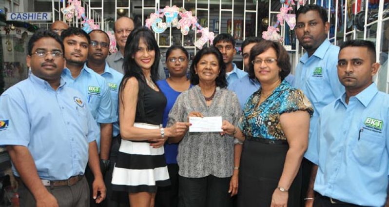 Staff of Ganesh Parts and the Doobay Medical Centre representative with cheque (centre)