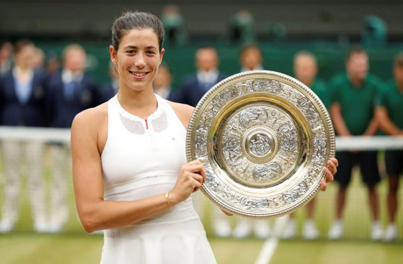 Spain’s Garbine Muguruza poses with the trophy as she celebrates winning the final against Venus Williams of the U.S.