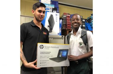 In this Mark Benschop photo, Audie’s son, Brandon Henriques makes a donation to Garfield Dover, who excelled at CSEC Examinations