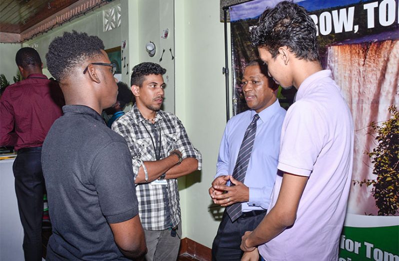 Director of the Department of Energy Dr Mark Bynoe chats with these young men at the close of the Guyana Youth for Tomorrow (GYFT) symposium