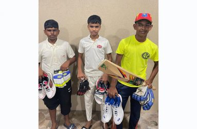 The three junior cricketers pose with their gear