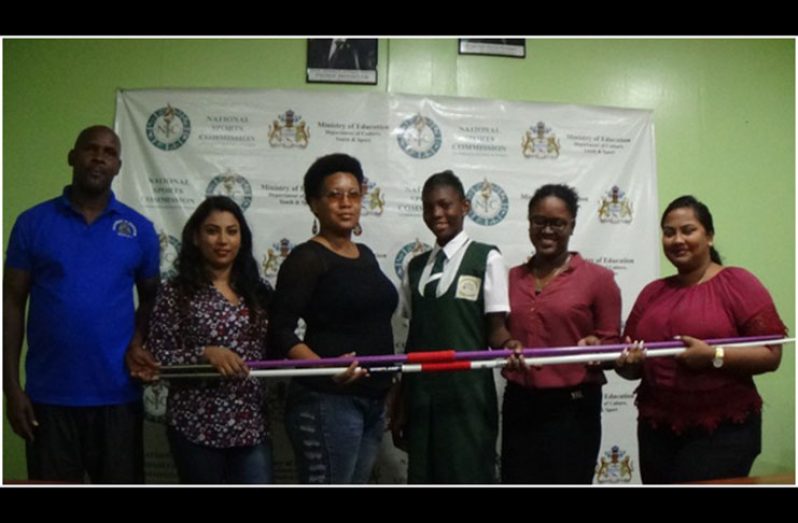 Several members of the NSC help Anisha Gibbons hold her new javelin.