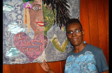 The artist beside her piece titled “Two Faced”
