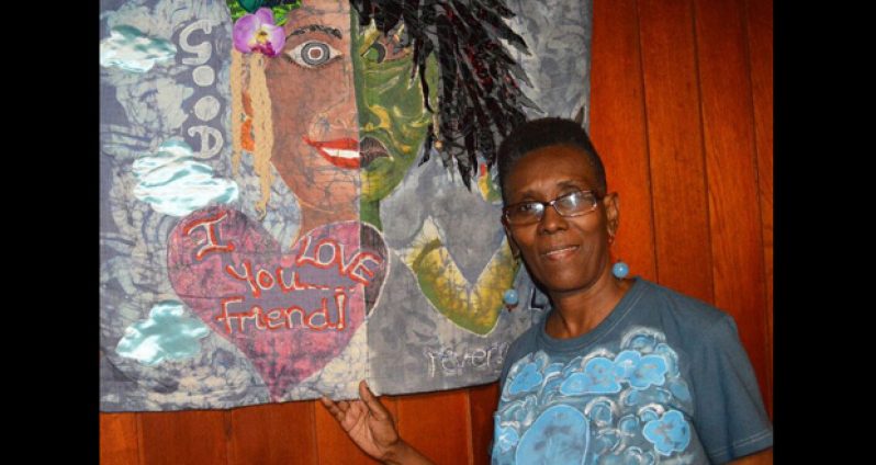 The artist beside her piece titled “Two Faced”