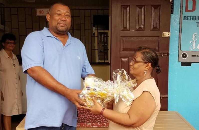 President of the BCB, Hilbert Foster, presents token to executive member, Angela Haniff.