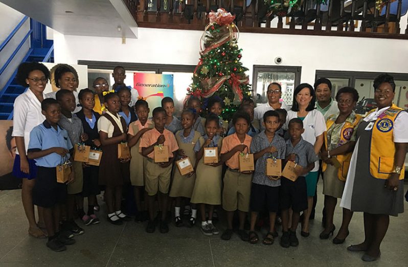 Members of the Ming’s Optical family stand with the Durban Park Lions and the students who received spectacles