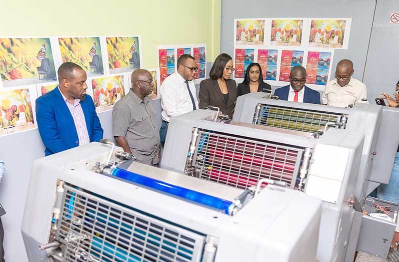 Minister Kwame McCoy inspects the recently acquired printing press, flanked by GNNL’s department heads and members of its Board (Delano Williams photo)