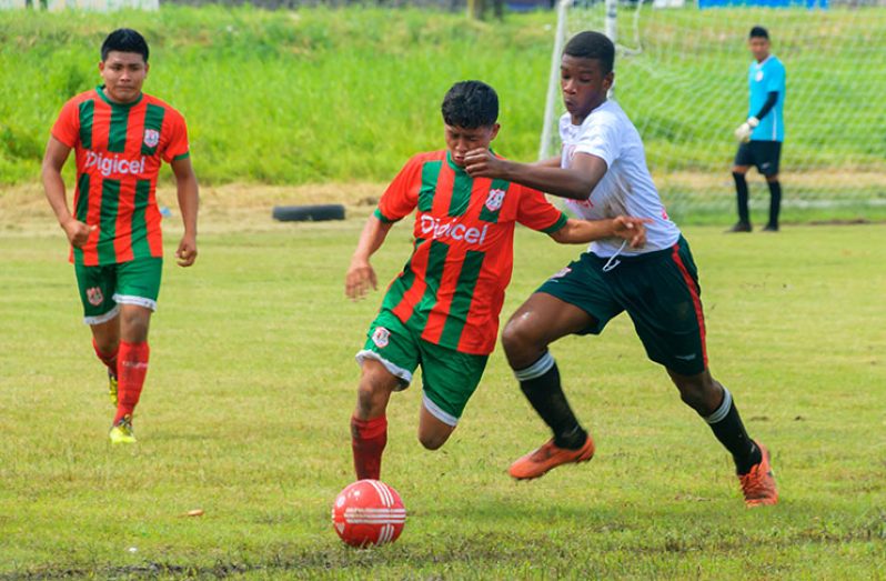 A Waramadong player, muscling his way past a Bartica defender, was indicative of how the Region Seven final was played. (Delano Williams photo)