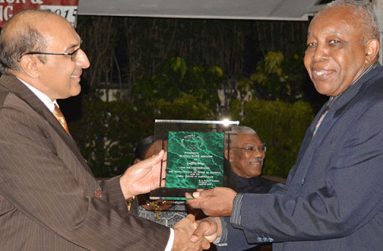 Editor of the Guyana Chronicle Godfrey Wray receives his award from GOA president K.Juman Yassin