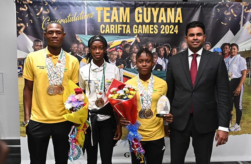 Golden! Some of Guyana’s medalists at the 2024 CARIFTA games. (from L-R) Malachi Austin, Tianna Springer and Athaleyha Hinckson’s stand with Minister of Culture, Youth and Sport, Charles Ramson.