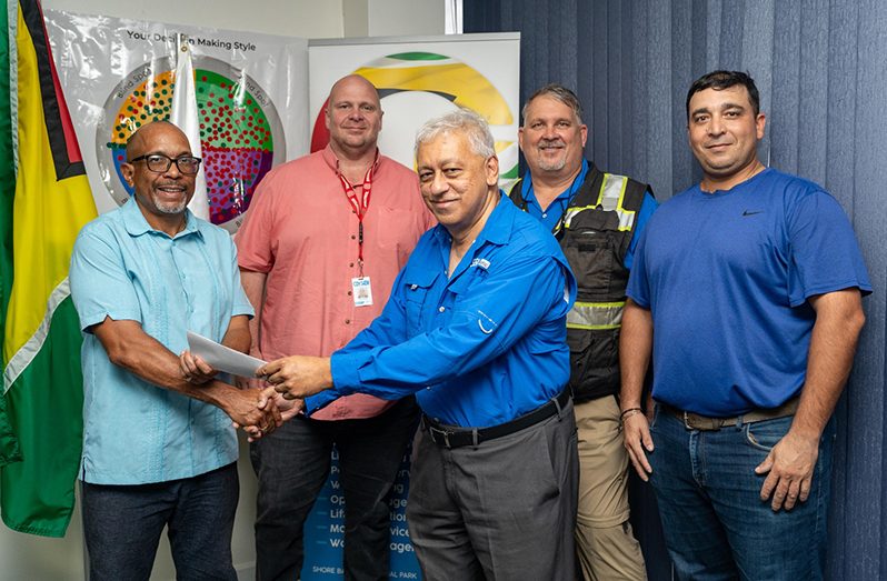 Robin Muneshwer, Executive Director of GYSBI (foreground, right) hands over the sponsorship cheque to LGC executives