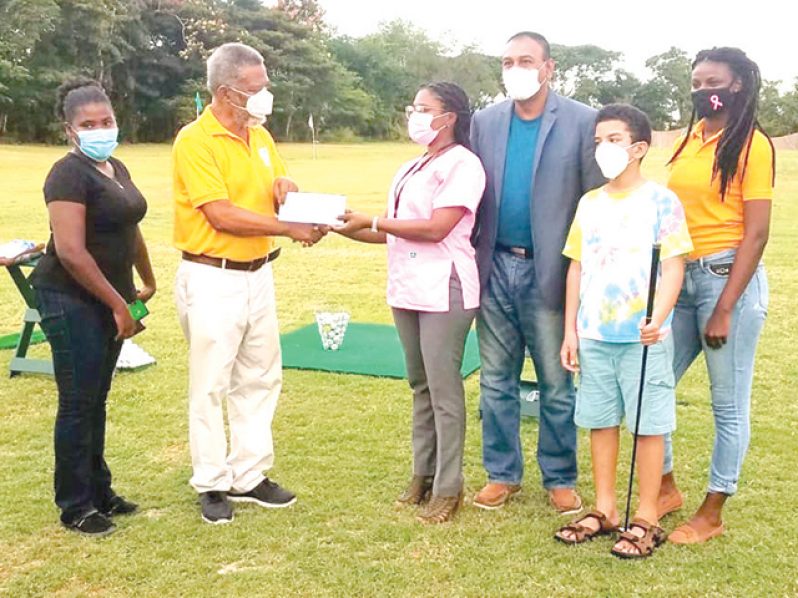 winner of the Women's Amateur division Leota King, ex-Prime Minister Sam Hinds hands over the check to Ms. Monette Harry of the Guyana Cancer Institute , Marcus Hinds Jr., GGA President Aleem Hussain