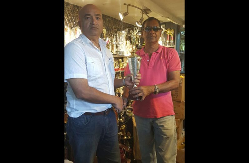 President Oncar Ramroop (left) receives a trophy – the symbol of Trophy Stall’s sponsorship – from Mr Ramesh Sunich, CEO of Trophy Stall.