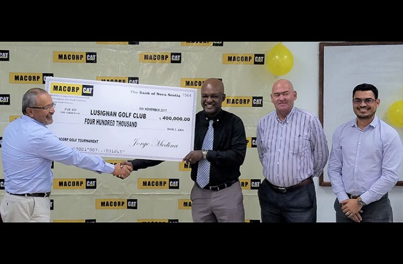Jorge Medina (left) hands over cheque to Brian Hackett in the presence of other MACORP and Lusignan Golf Club officials.