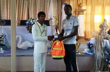 Chanderpaul Govindan receives his award as Cricketer-of-the-Year from coach Eon Hooper.