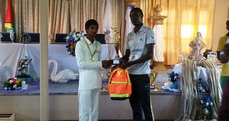 Chanderpaul Govindan receives his award as Cricketer-of-the-Year from coach Eon Hooper.