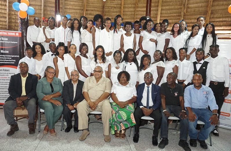 Graduates pose with official from the board of industrial training