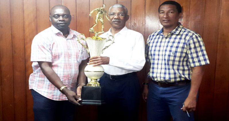 Leader of the Opposition and Presidential candidate for the APNU+AFC coalition, David Granger, hands over his ‘Fair Play’ trophy to Aubrey ‘Shanghai’ Major and Kashif Muhammad yesterday.